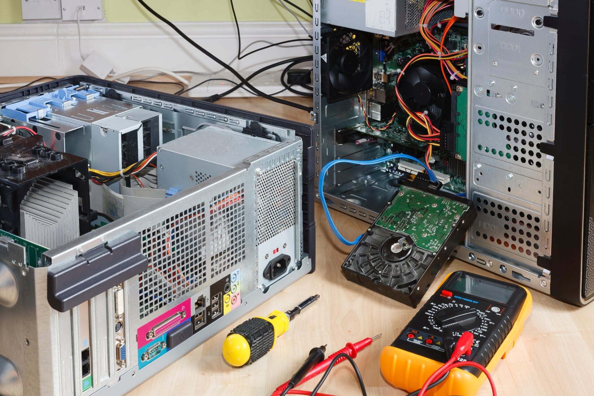 Open desktop computers and diagnostic tools on a repair workbench