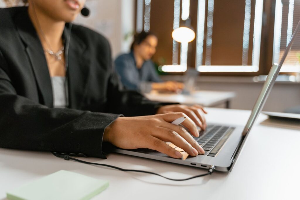 Business support professional working at a computer with a headset